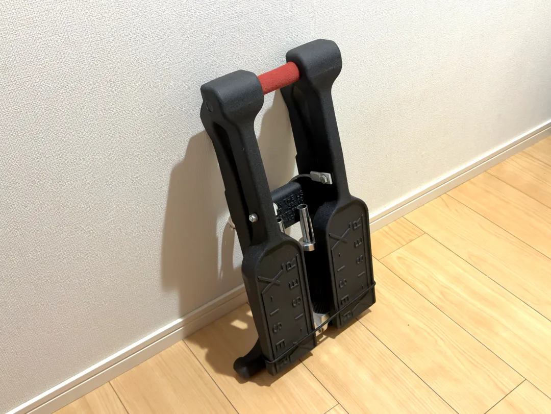 立てかけたり家具の下に収納できるほど、平べったく折りたたむことが可能。赤い部分は持ち手になっていてスポンジが巻かれており、可搬性が高い。