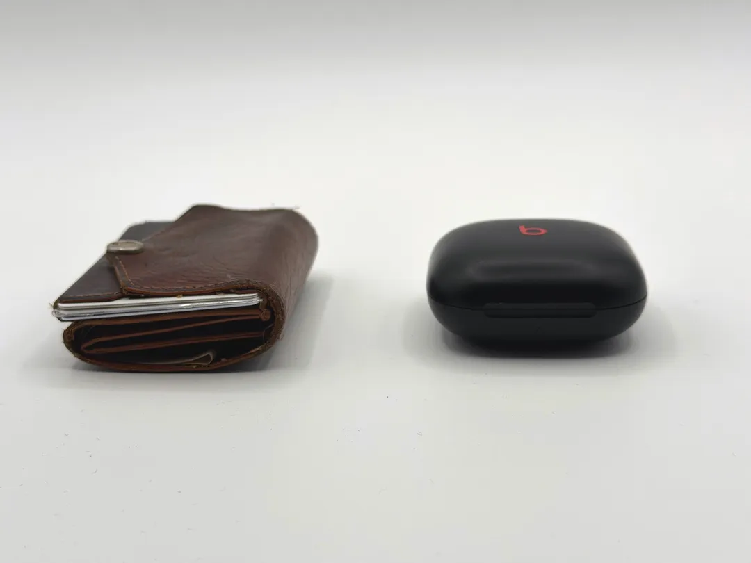 分厚くはないが、薄いとも言えない。右は Beats Fits Pro というワイヤレスイヤホンのケース。